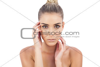 Cute woman holding her head and looking at camera