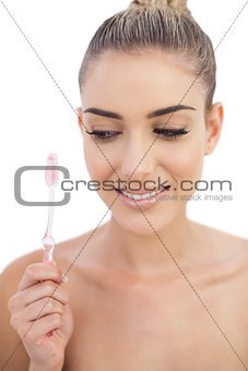 Pleased woman holding a toothbrush