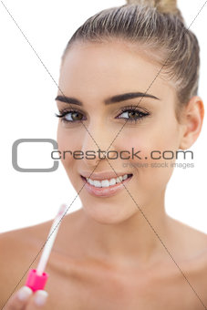 Cheerful woman applying gloss on her lips