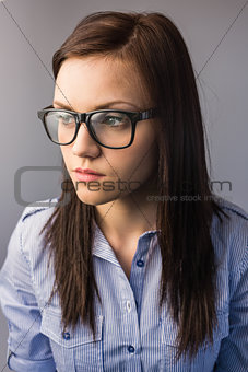 Thoughtful pretty brunette wearing glasses posing