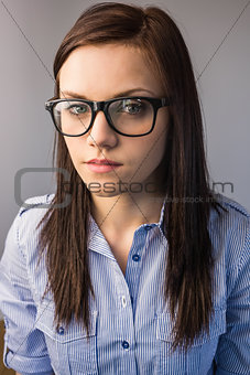 Serious pretty brunette wearing glasses posing