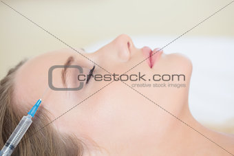 Surgeon making injection on relaxed woman lying