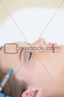 Surgeon making injection on peaceful woman lying