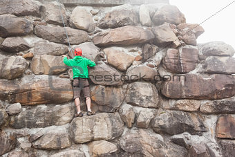 Determined man scaling a large rock face