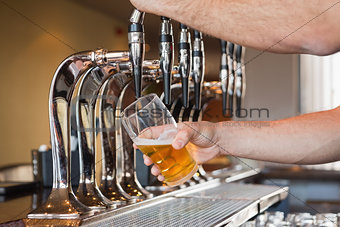 Mans hand pouring beer
