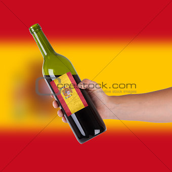 Hand holding a bottle of red wine