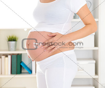 Pregnant woman applying lotion cream