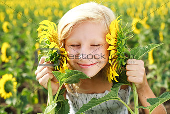 Young girl in the field playing with sunflowers