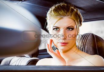 young woman looking in rear view mirror car