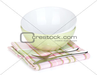 Salad bowl and silverware over kitchen towel