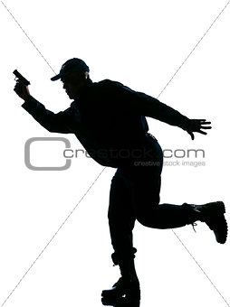 Silhouetted police man running with a handgun