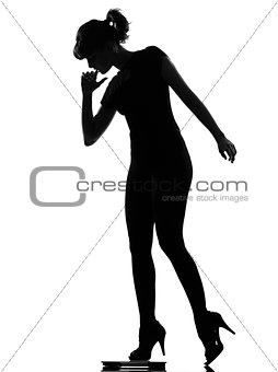 silhouette woman stepping on personal weight scale