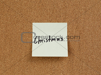 christmas reminder note on cork board