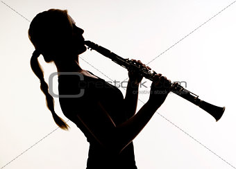 Female Musician in Silhouette Practices Woodwind Technique on Cl