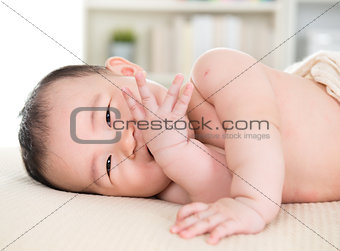 Asian baby girl biting fingers
