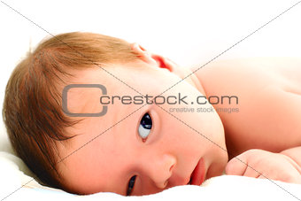 Portrait of a baby lying on white.