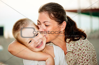 Mother kissing her child's cheek.