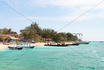 Small wooden long boats on blue sea