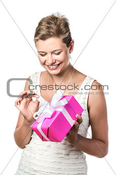Young pretty woman unwraps gift