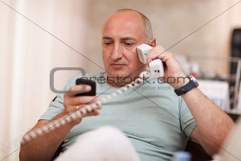 Businessman in the office speaking on two phones