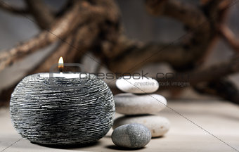 burning candle with pebbles. abstract still life