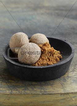 nutmeg whole and grated in a wooden bowl