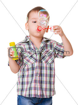 Boy blowing soap bubbles on white