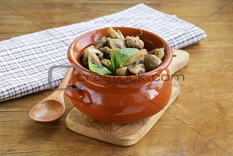 mushroom ragout of champignons and basil on a wooden table