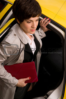Attractive Business Woman Enters a Yellow Taxi Cab