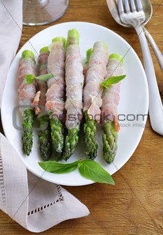 appetizer of fried asparagus with ham and basil