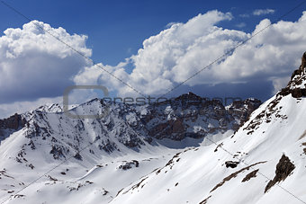 Snowy mountains and blue sky with cloud in sunny spring day