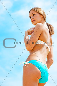 Sexy girl in a bathing suit against the sky.