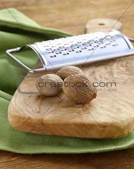 nutmeg whole and grated on a wooden table