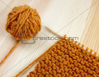 Closeup of garter stitch knitting and orange wool