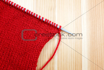 Stocking stitch in red wool on a knitting needle