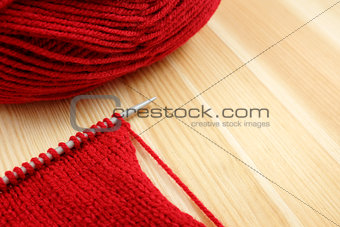 Stockinette stitch on knitting needle with red wool