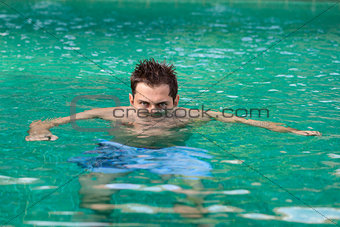 Young serious man in swimming pool 