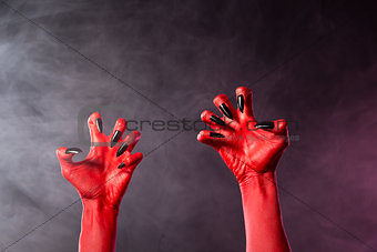 Spooky red devil hands with black glossy nails  