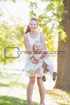 Happy mother and baby having fun outdoors