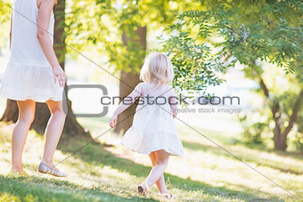 Mother and baby running in forest