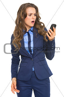 Surprised business woman looking on cell phone