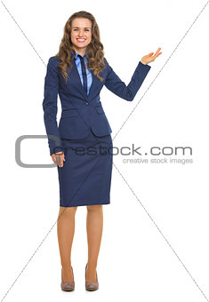 Full length portrait of smiling business woman showing something