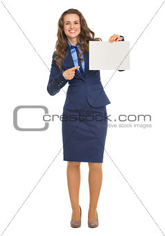 Full length portrait of smiling business woman pointing on blank