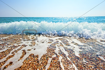 Splash of sea foam on a sandy beach
