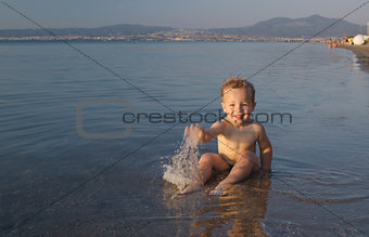 Cute little boy splashing in the sea