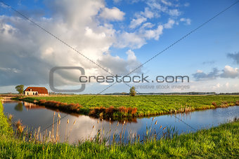 beautiful clouds over farmhouse and river
