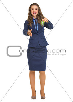 Smiling realtor woman giving keys and stretching hand for handsh