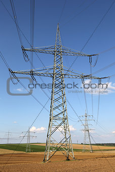 Electricity pylons and lines on a field