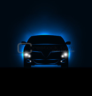 Silhouette of car with headlights in darkness 
