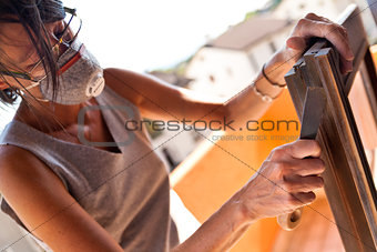 Woman polishing a window with a putty knife